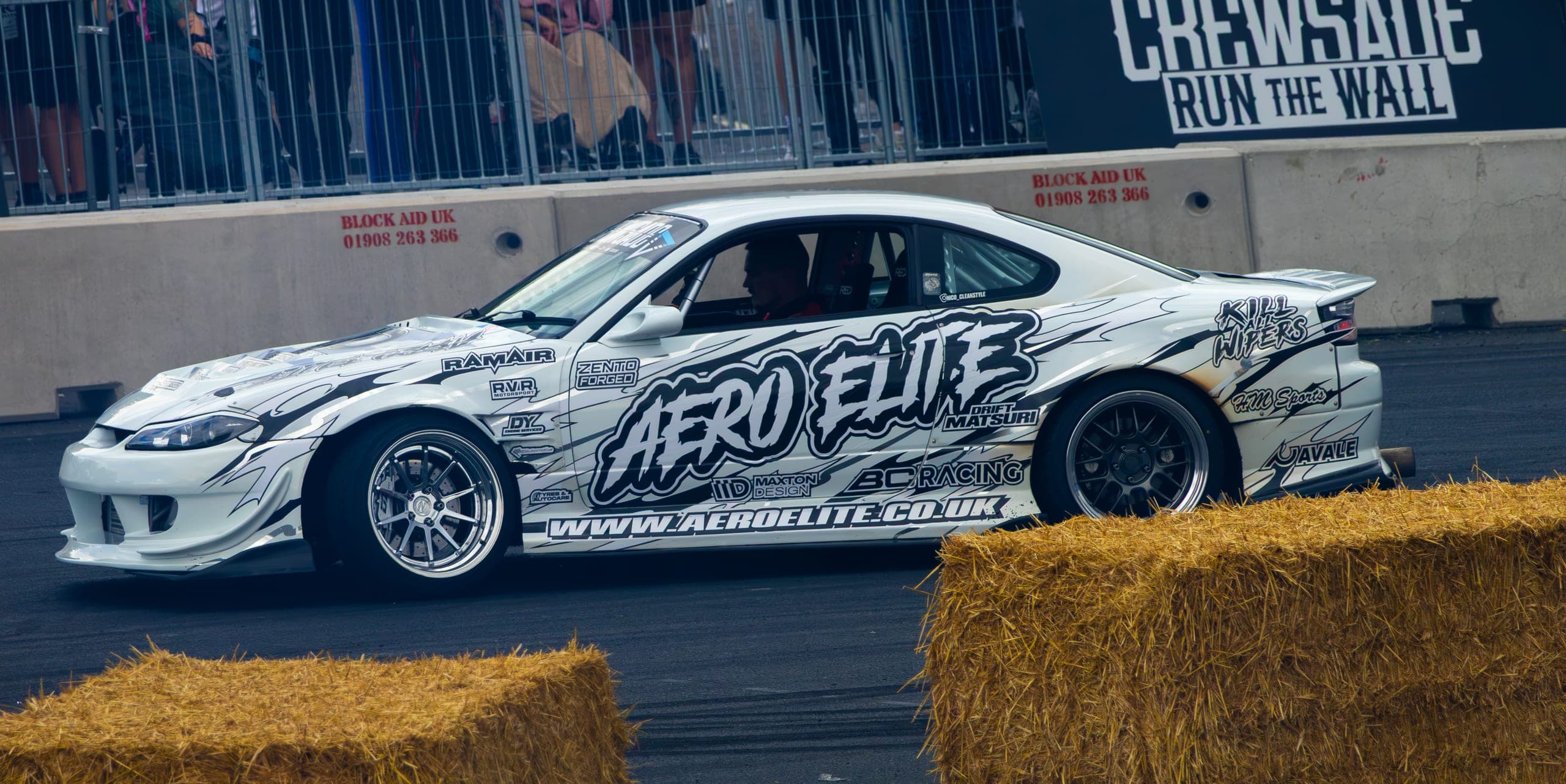A liveried drift car sideways past the bale line, Gravity 2026