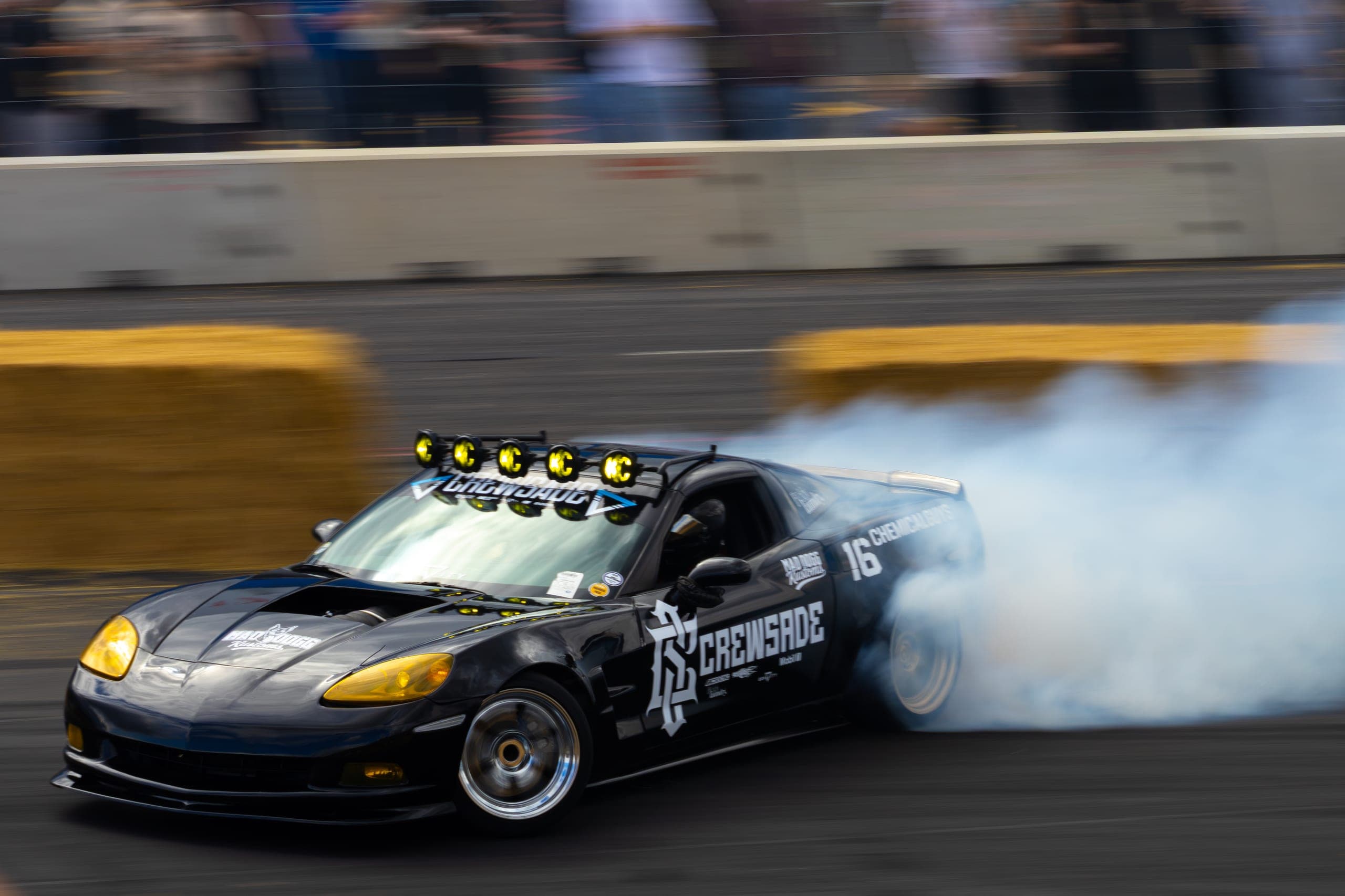 A drift car at full steering lock trailing tyre smoke, Gravity 2026
