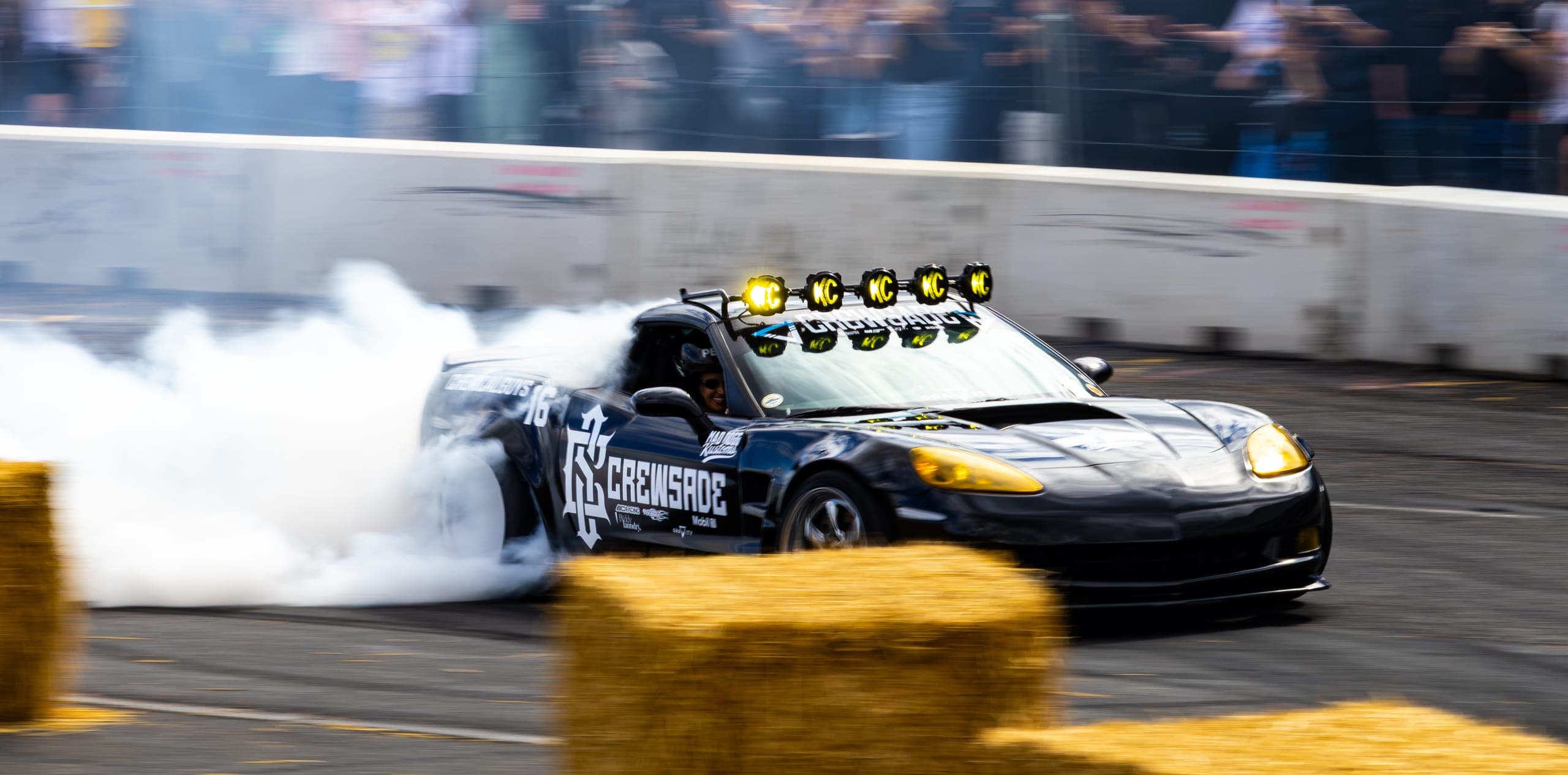 A drift car emerging front-first from a bank of tyre smoke, Gravity 2026