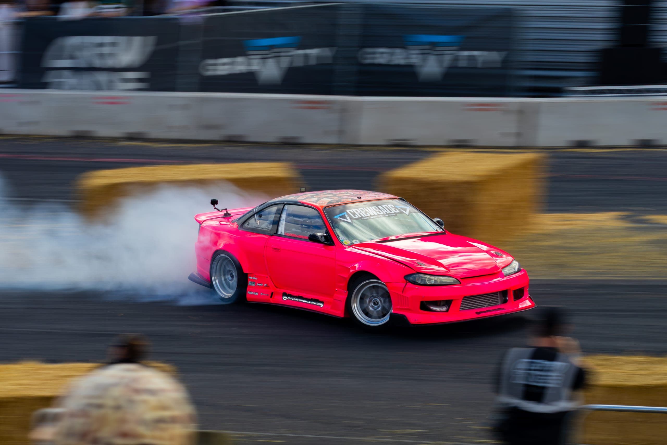 A bright pink drift car low and sideways through the smoke, Gravity 2026