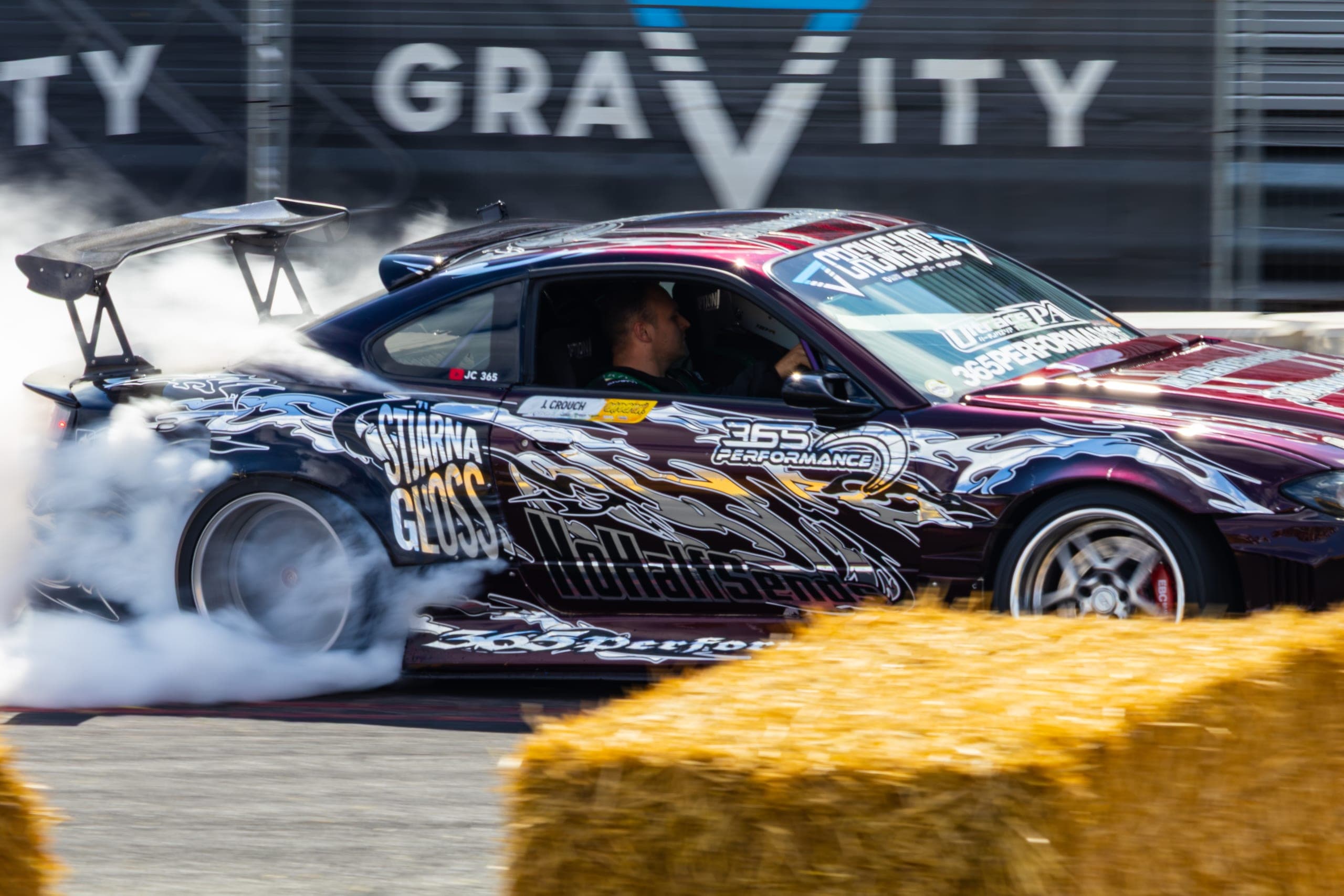 A drift car sideways beneath the event banner, Gravity 2026