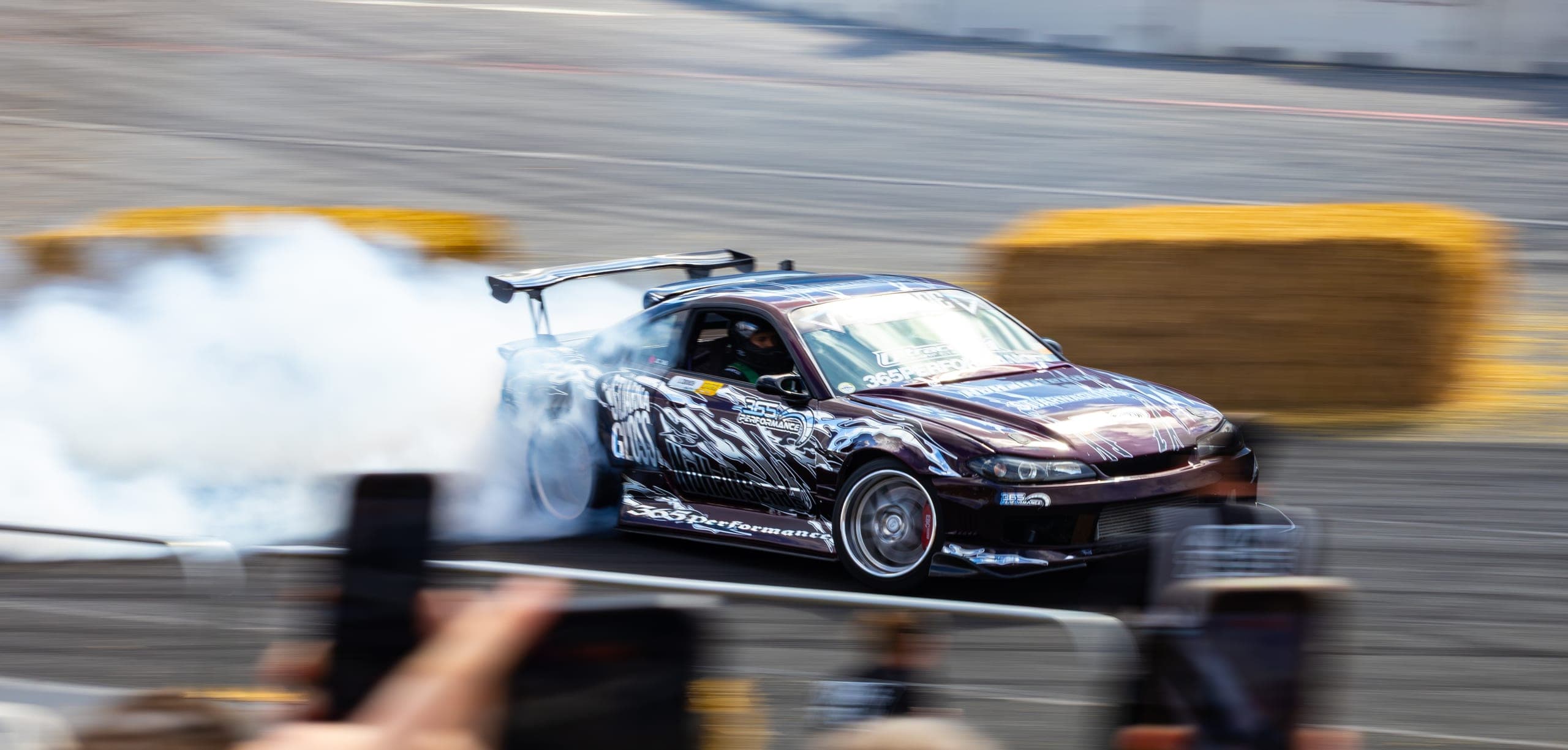 A winged drift car fully committed and buried in smoke, Gravity 2026