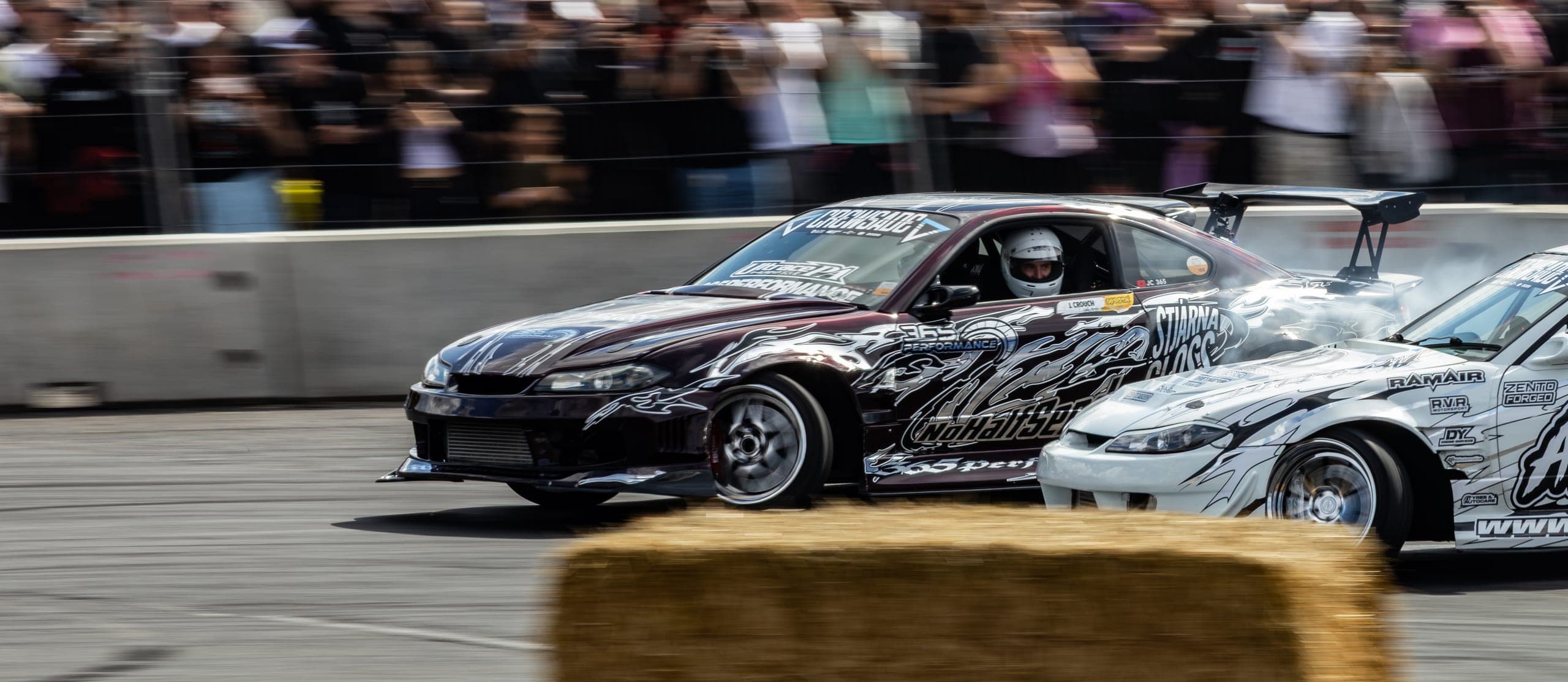 A helmeted driver at full lock, front three-quarter view, Gravity 2026