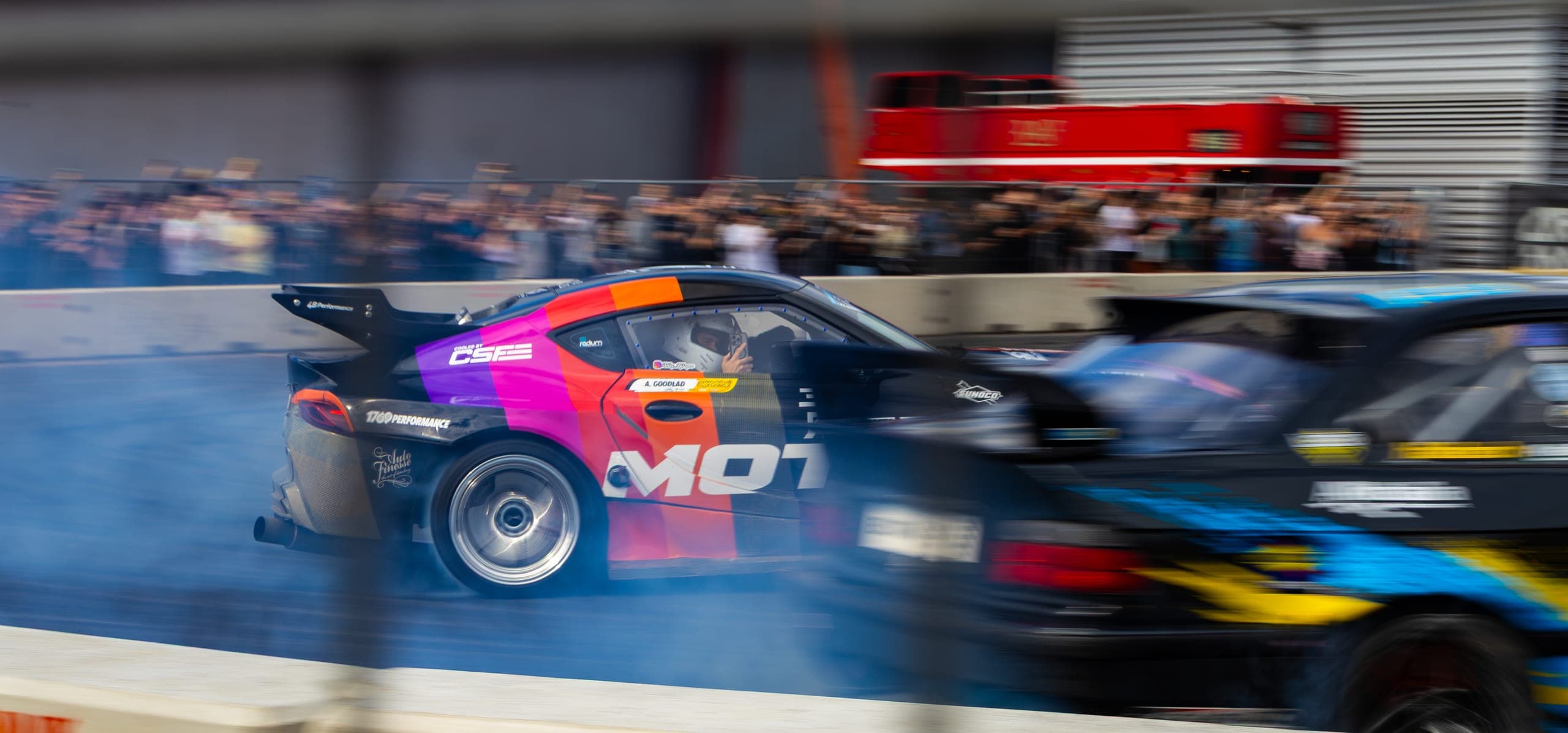 A brightly liveried drift car seen from behind mid-drift, Gravity 2026
