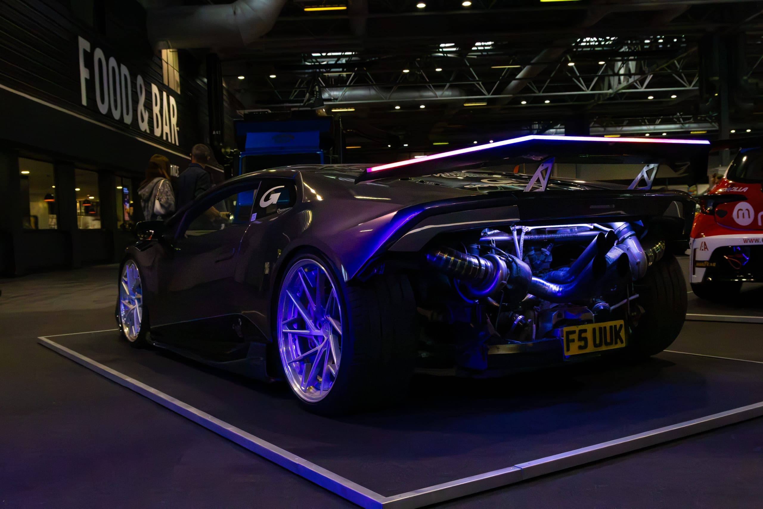 A show car lit from beneath on the exhibition floor, Gravity 2026