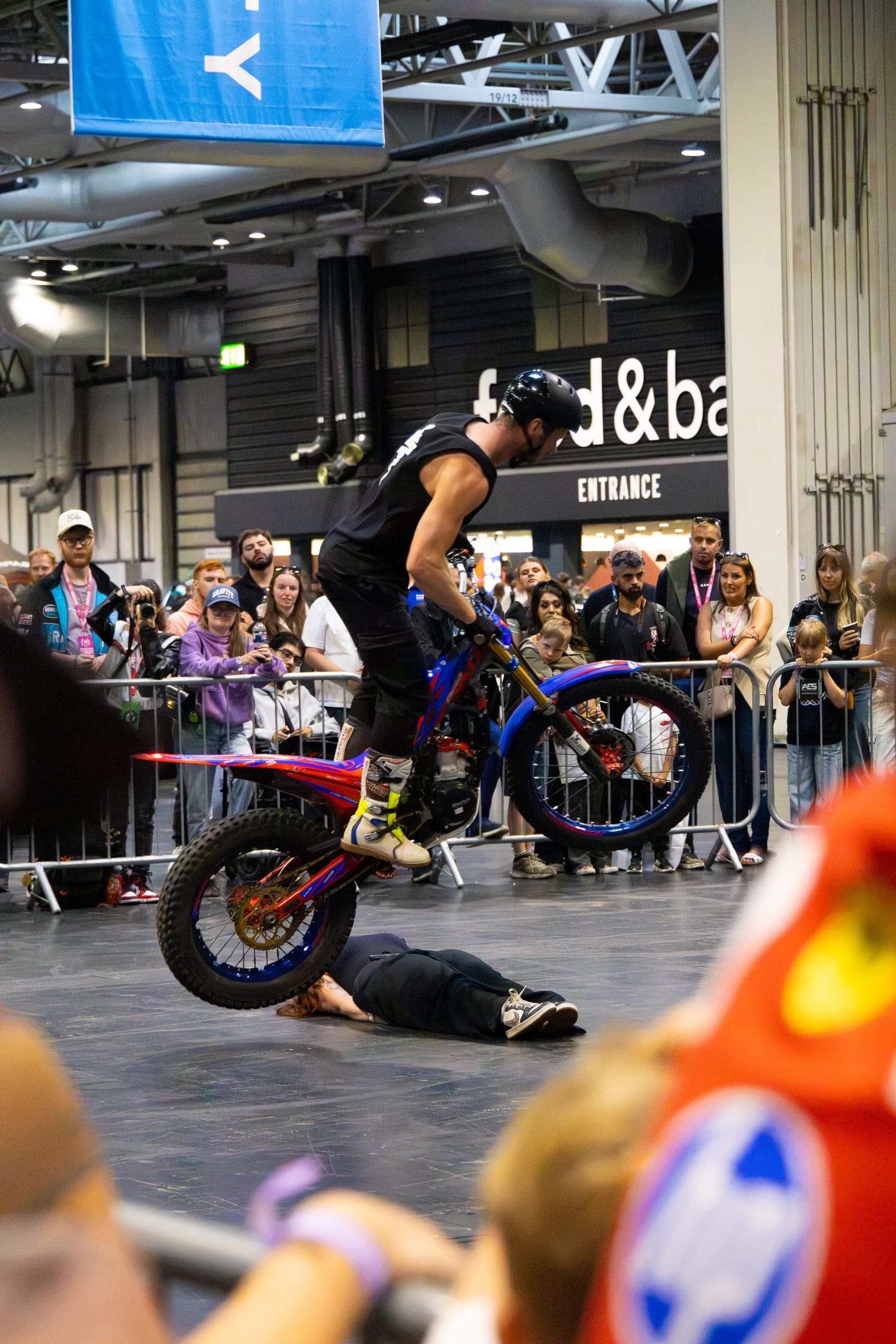 A stunt rider holding a wheelie in front of the crowd, Gravity 2026