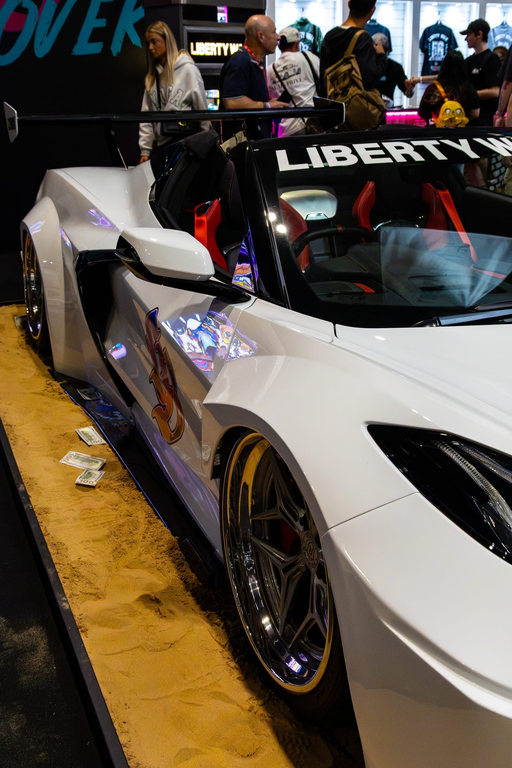 A white widebody supercar under exhibition lighting, Gravity 2026