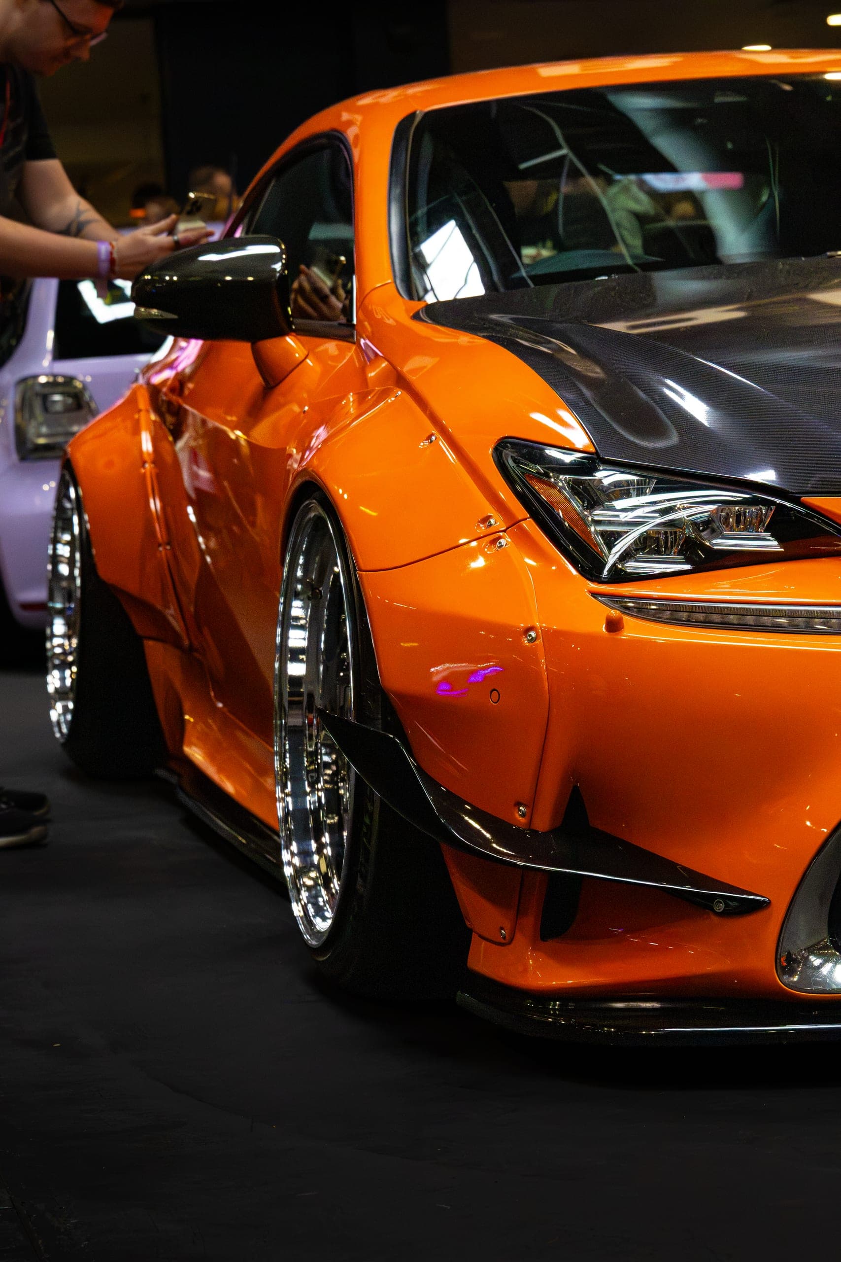 An orange widebody with flared arches, front three-quarter, Gravity 2026