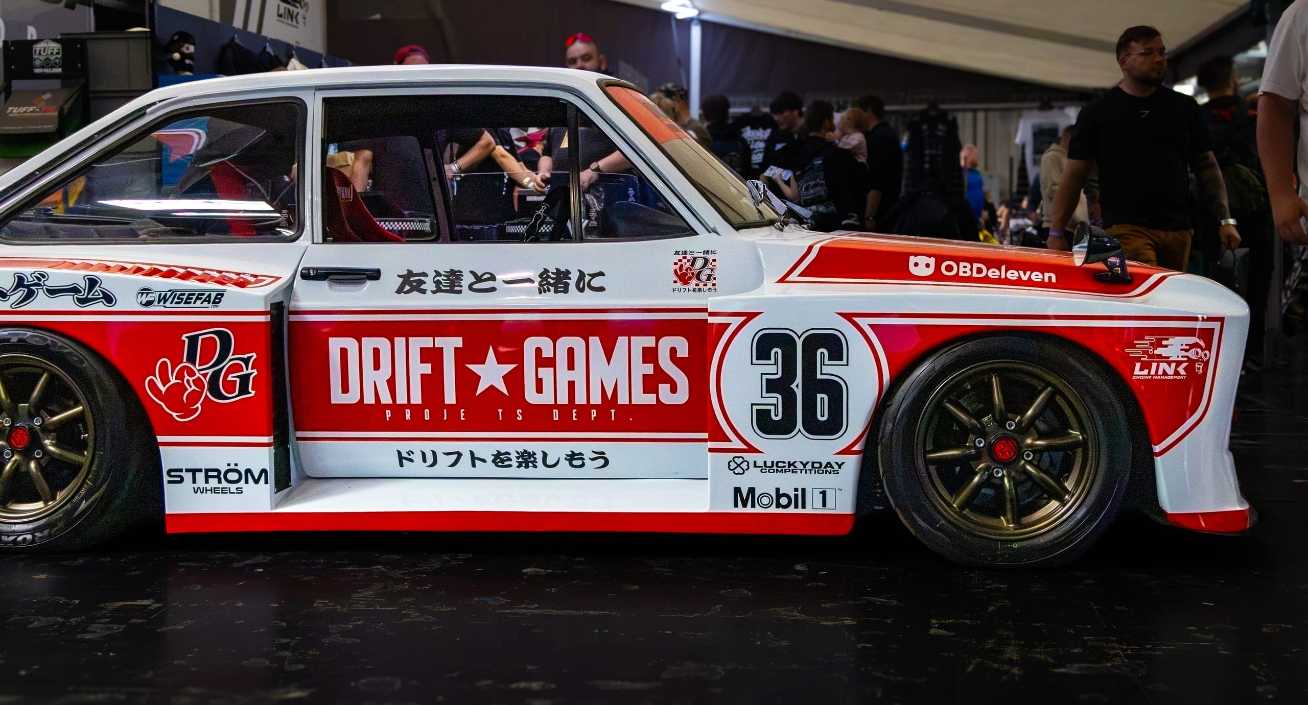 A liveried competition car displayed on a stand, Gravity 2026
